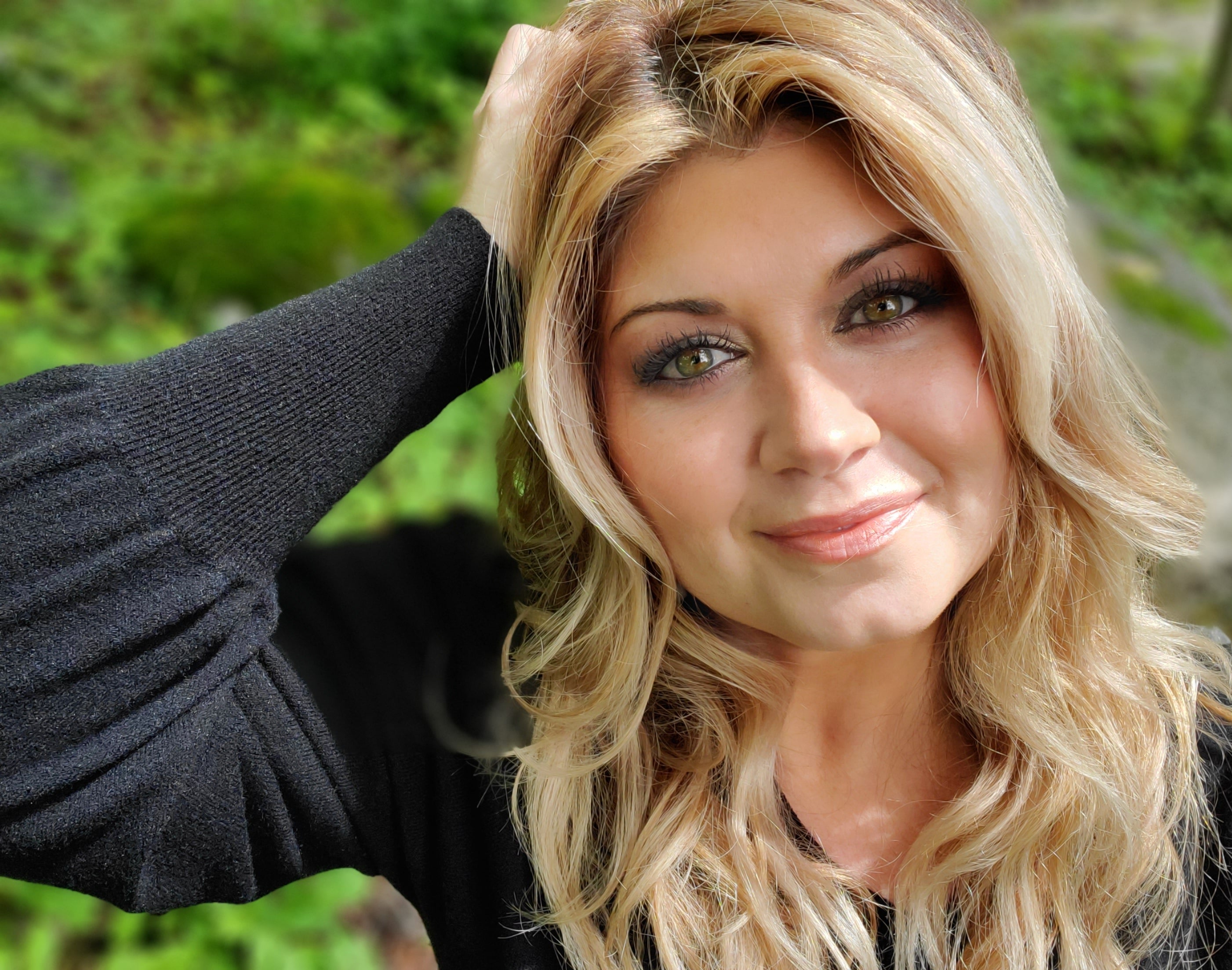 Woman with blonde hair and dark eyes outdoors