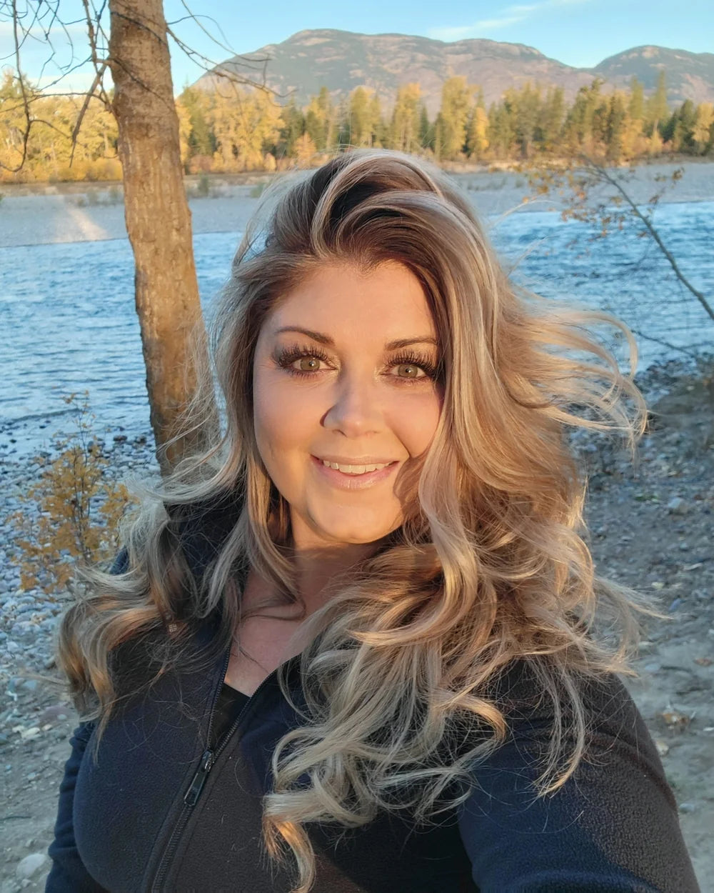 Jenn Hallowes by a mountain river at golden hour